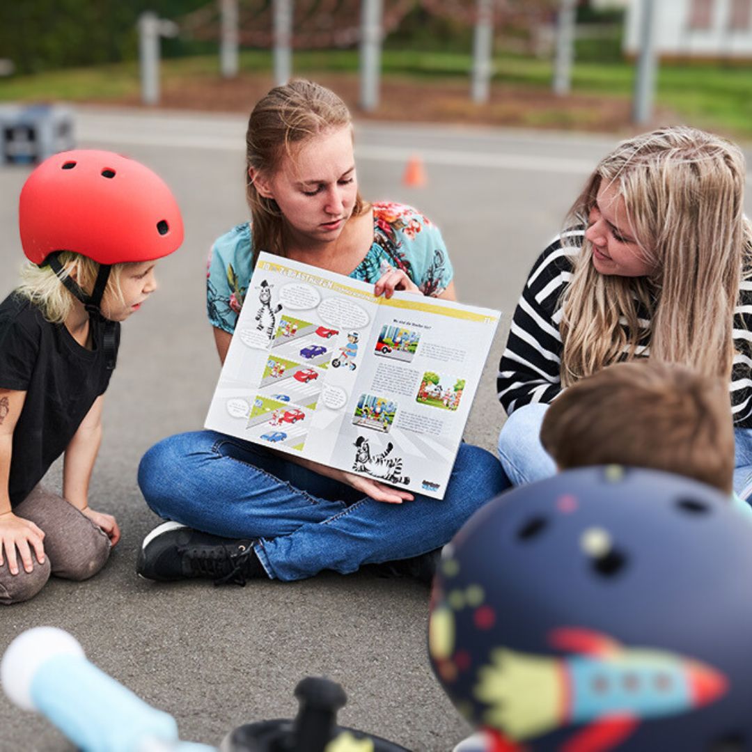 Erzieherinnen lesen gemeinsam mit den Kindern das ASPHALT-HELDEN Booklet - (C) Marusia Luft